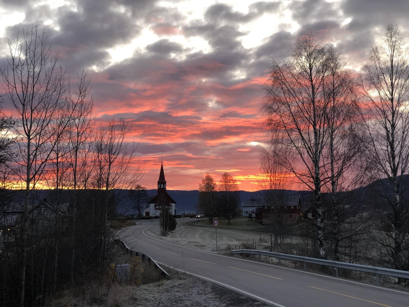 Kirke i silhuett mot en rød soloppgang